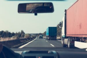 Driver practicing safe driving on a highway, ensuring the safety of themselves and others, with clear road signs and vehicles in the background.